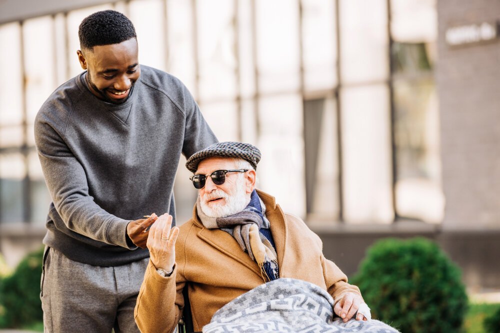 Cannabis for Seniors. African American Man Giving Joint To Senior Disabled Man.