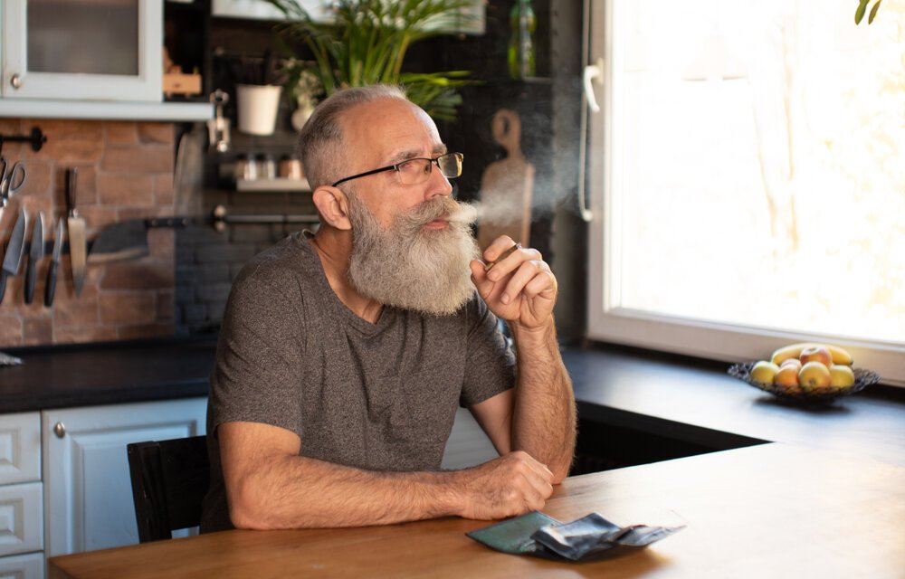 Cannabis for Seniors. Bearded Senior Man Smoking Marijuana,(weed Cannabis) At Home.