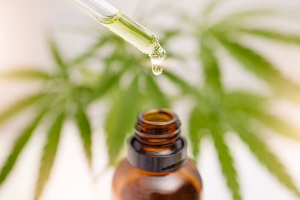 Cannabis and Mental Health for PTSD. Bottle showing with leaves in the background.